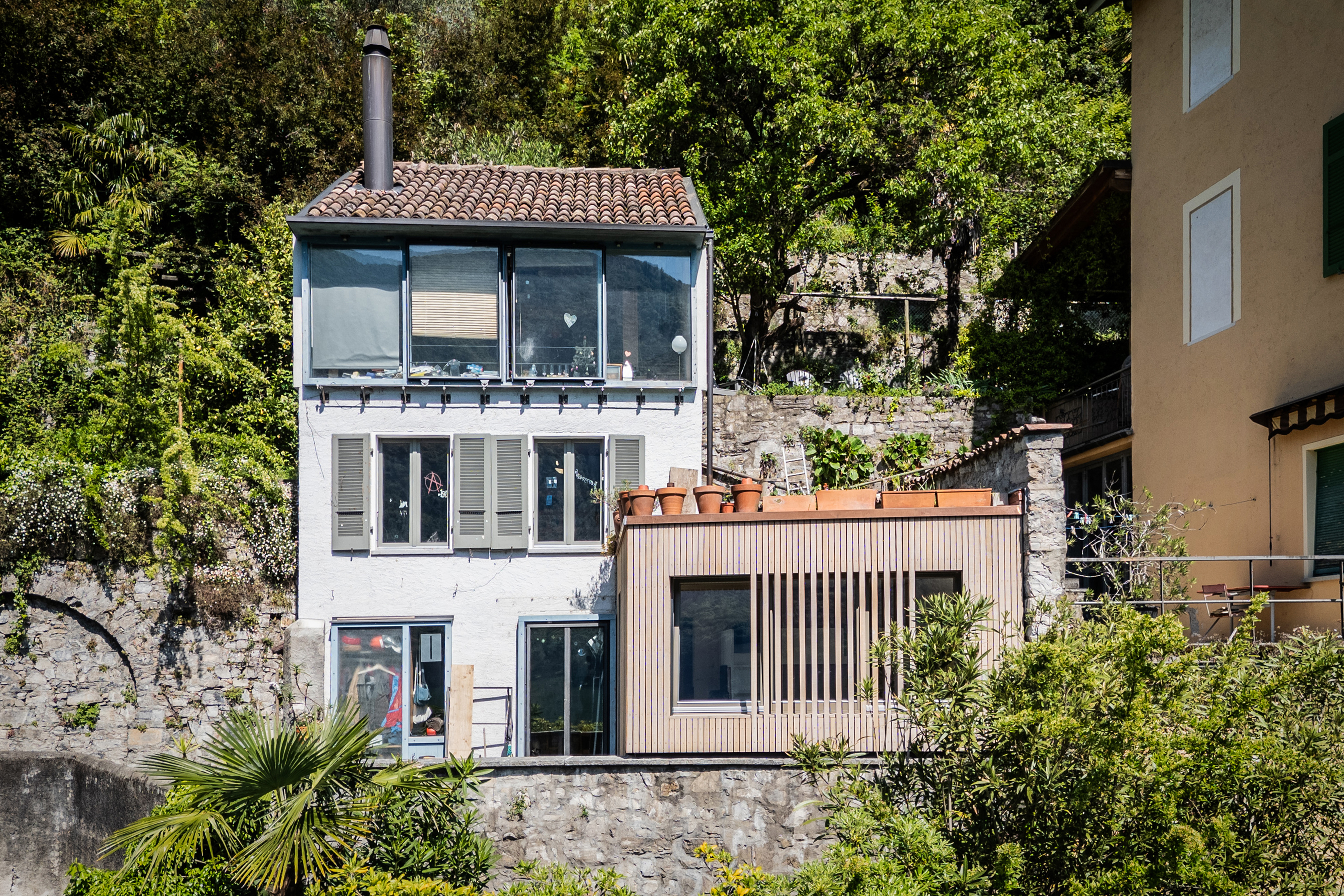 Ingrandimento in legno di una mini-casa in riva al lago